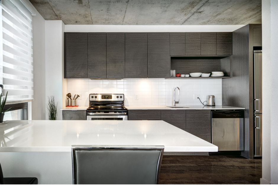 A kitchen with stainless steel appliances and gray cabinets