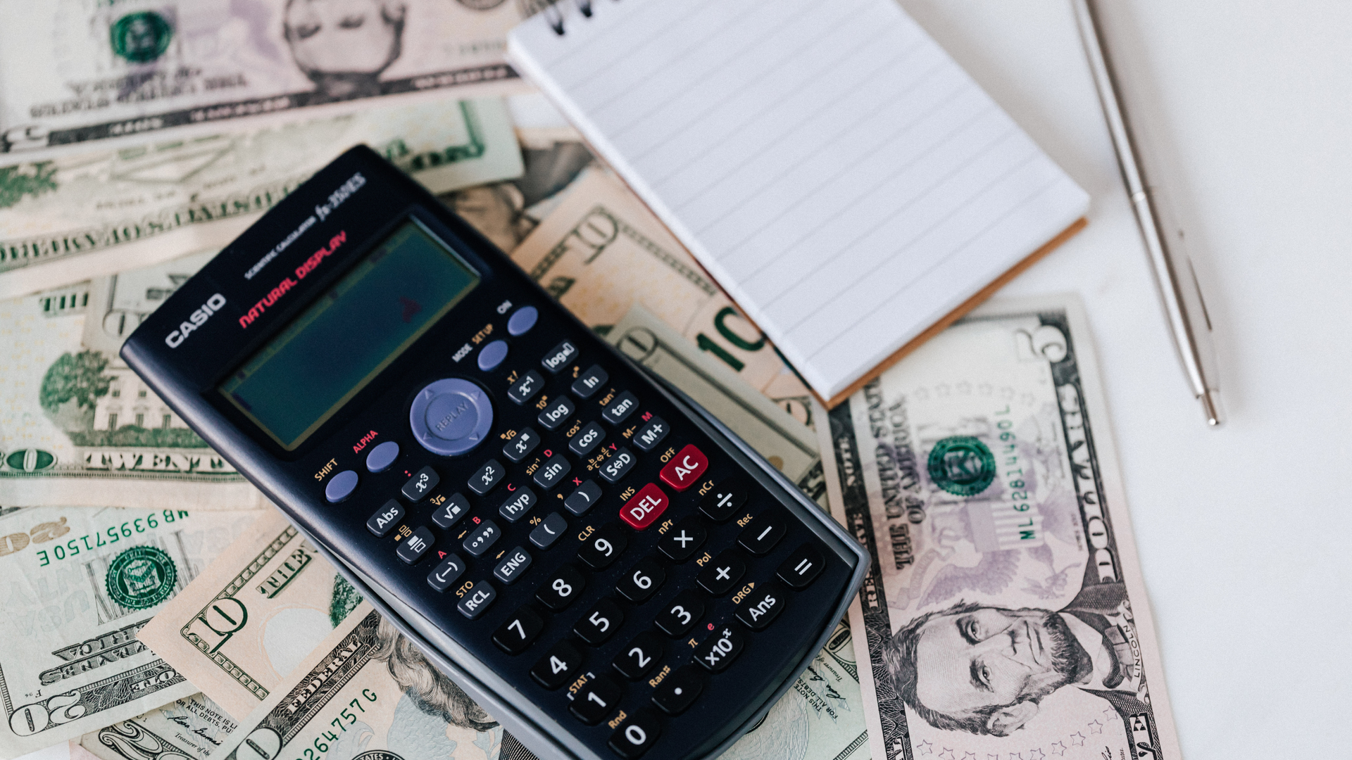 calculator and dollar bills on a table