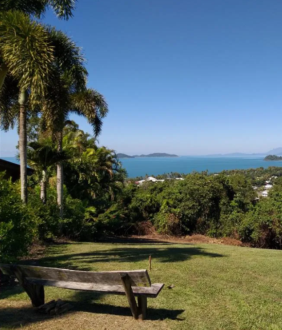 A Woman is Sitting at a Table Giving a Man a Set of Keys — Mission Beach Property Management in Wongaling Beach, QLD