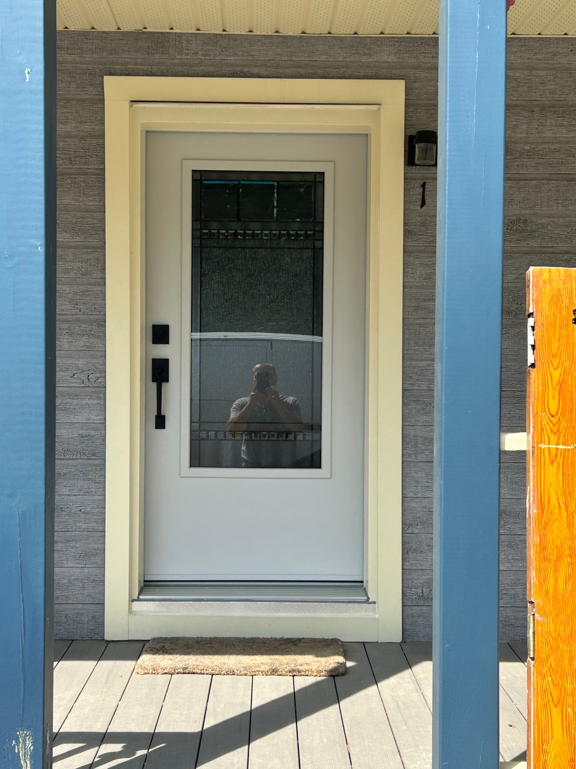 Une porte blanche avec le reflet d'une personne à l'intérieur