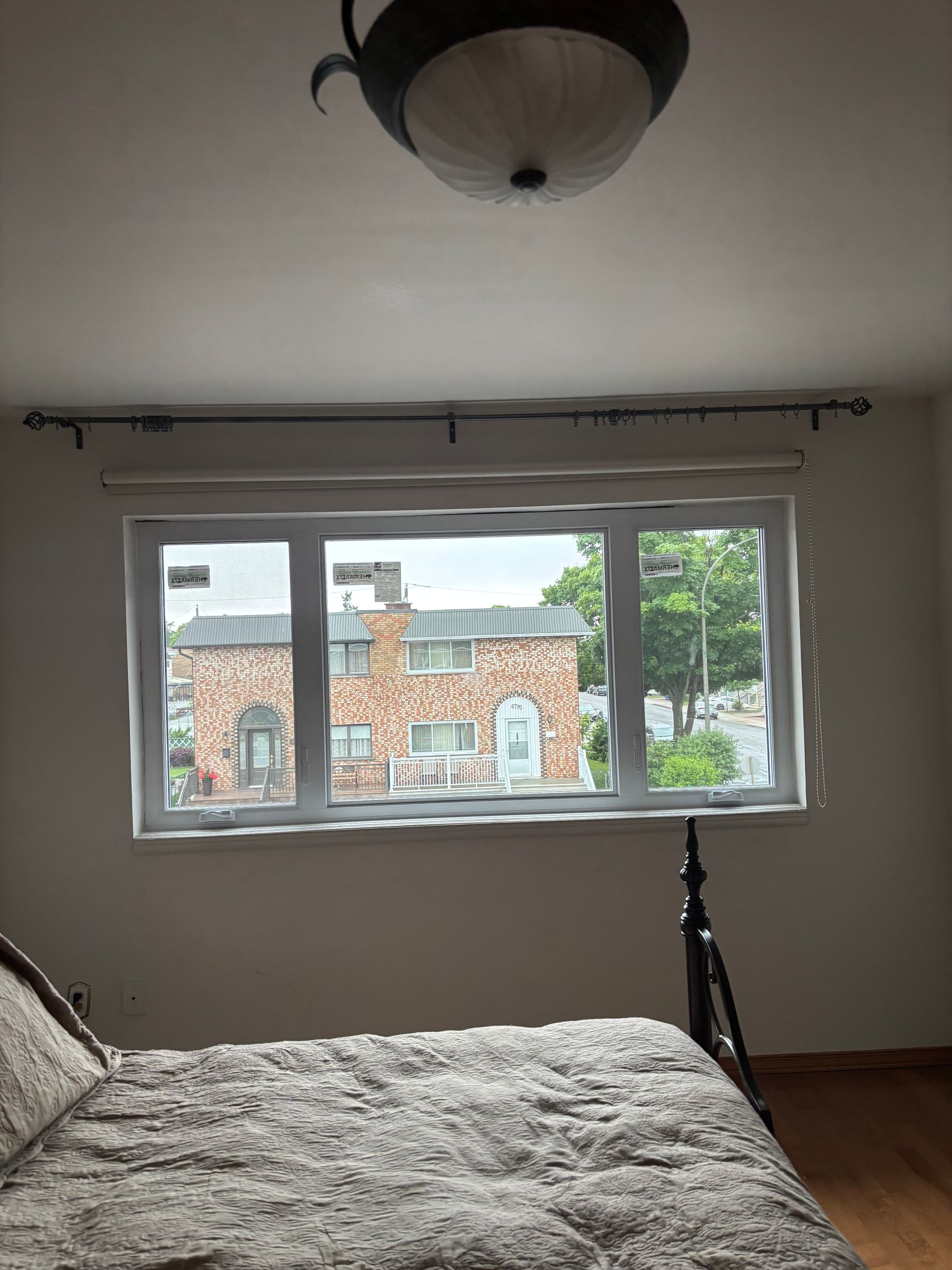 Une chambre avec un lit et une grande fenêtre.