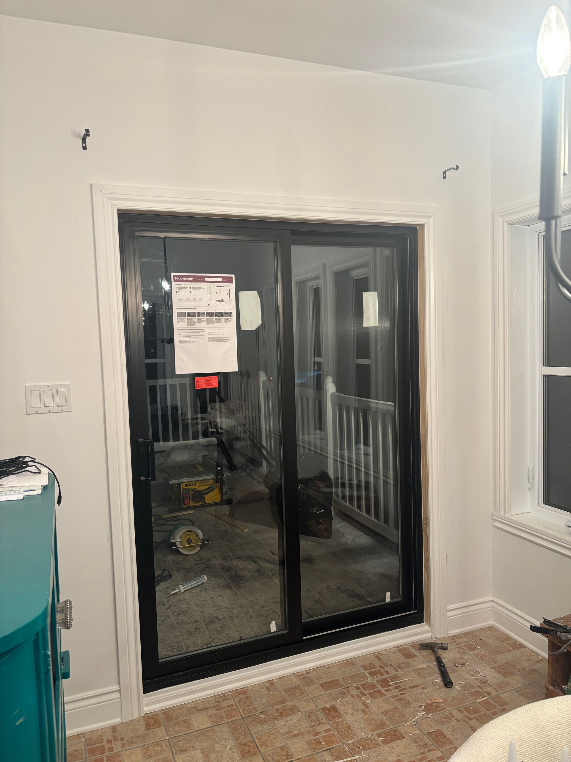 Porte coulissante en verre à cadre noir et garniture blanche, vue intérieure.