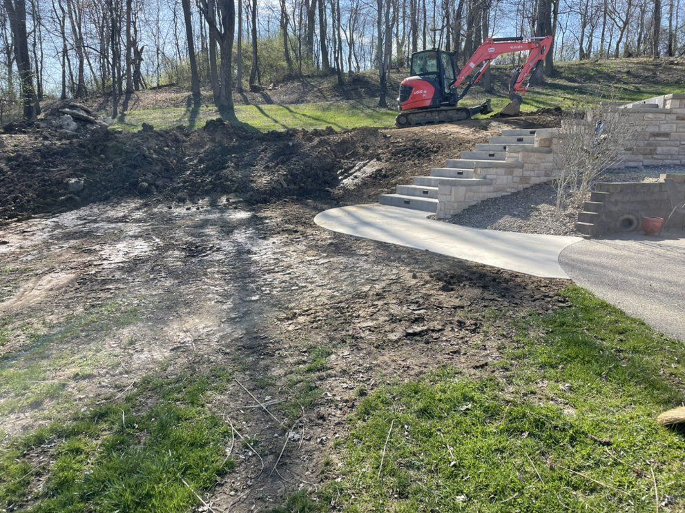 A red excavator is driving down a dirt road.