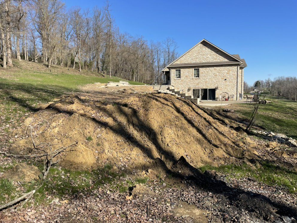 There is a large pile of dirt in front of a house.
