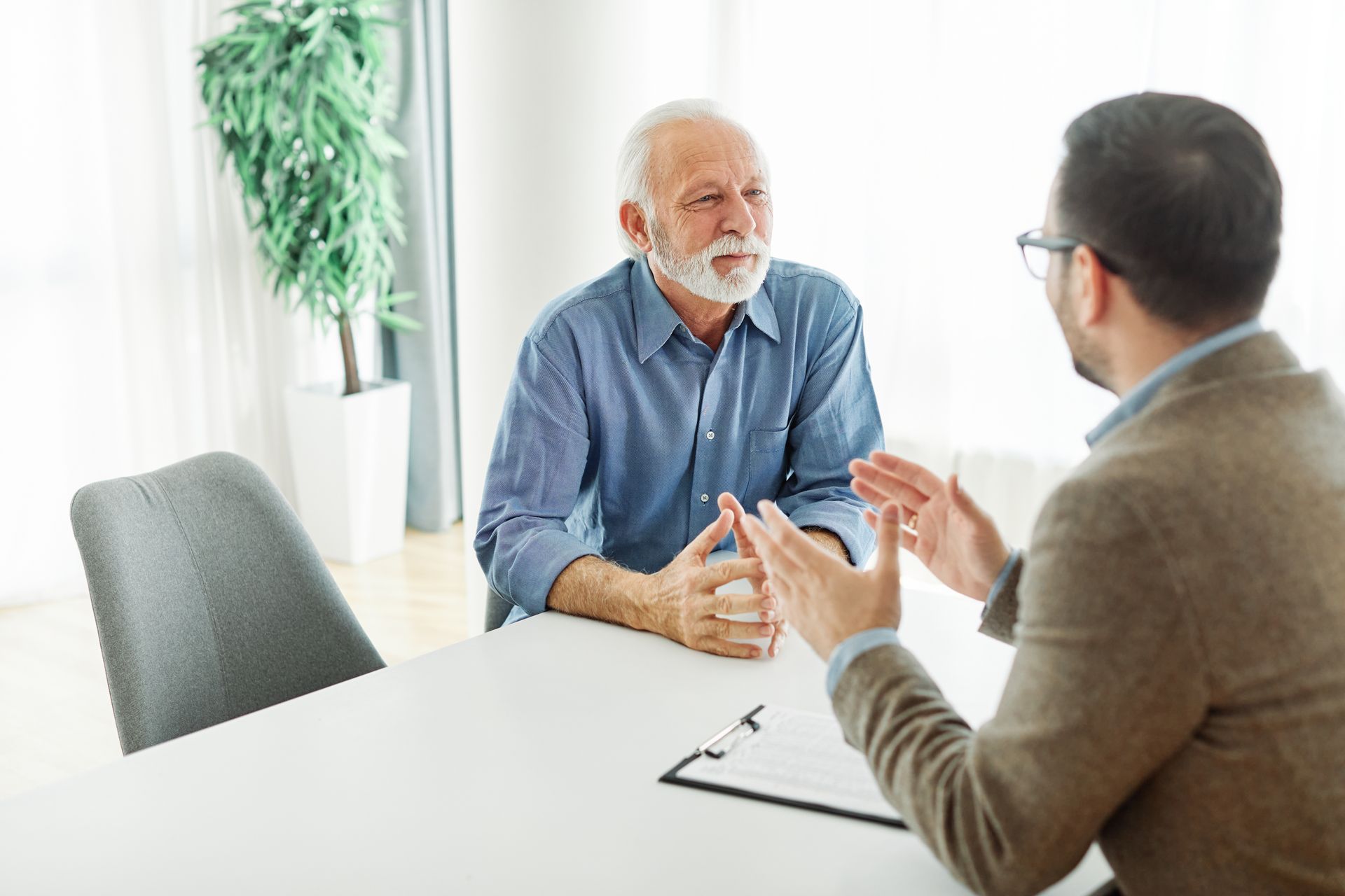 A real estate lawyer meets with an older man, discussing real estate legal matters