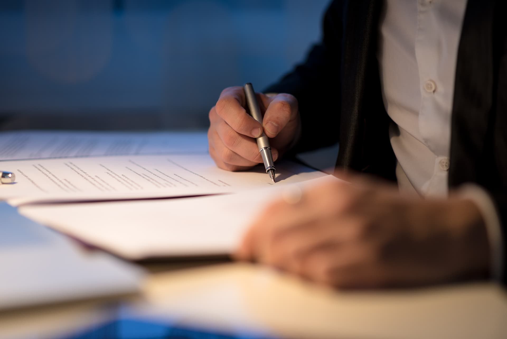 a person is writing on a piece of paper with a pen