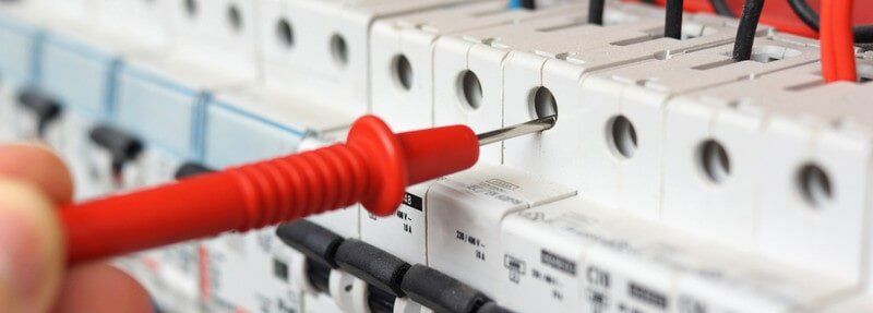 A person is using a multimeter to test an electrical box - Electrician in Emerald | All Saints Electrical