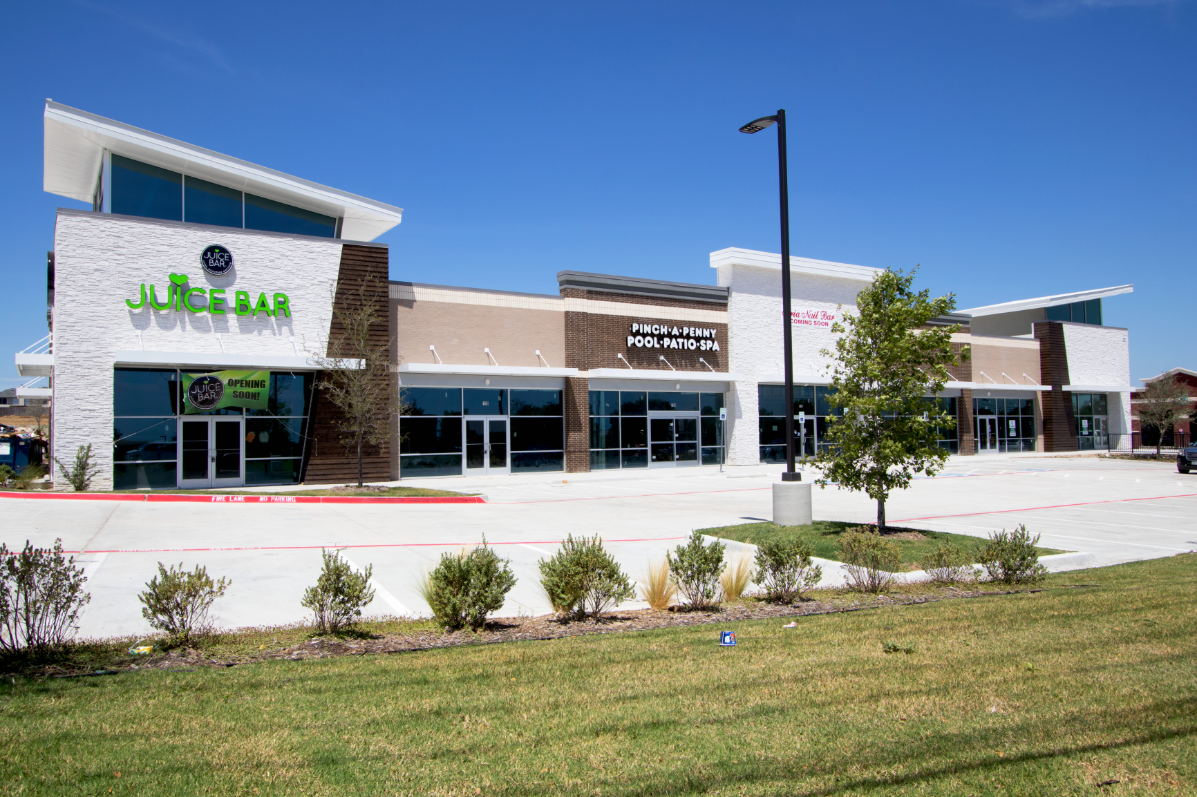 A large building with a lot of windows and a lot of grass in front of it.