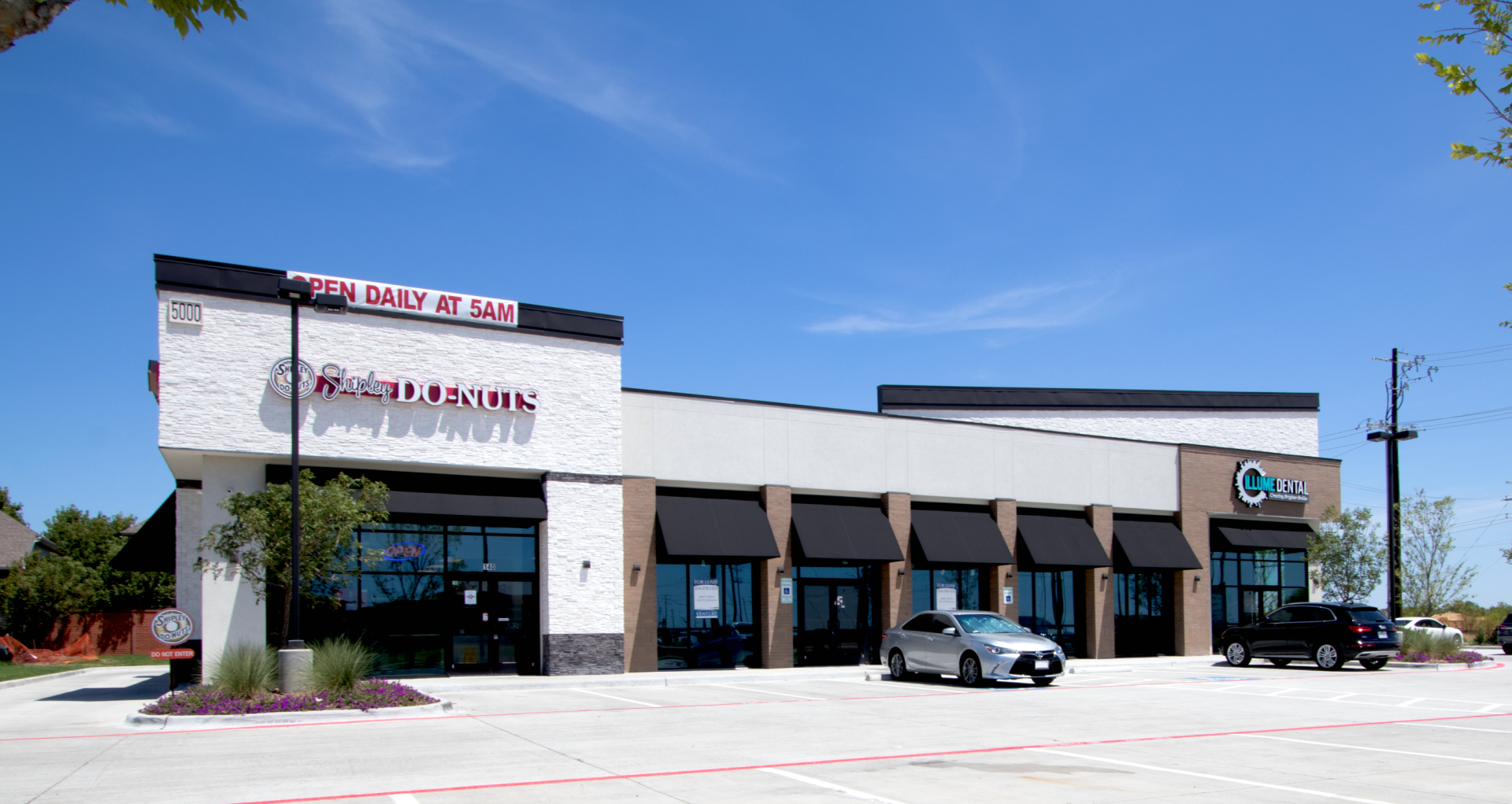 A car is parked in front of a building with a sign that says ' a ' on it.