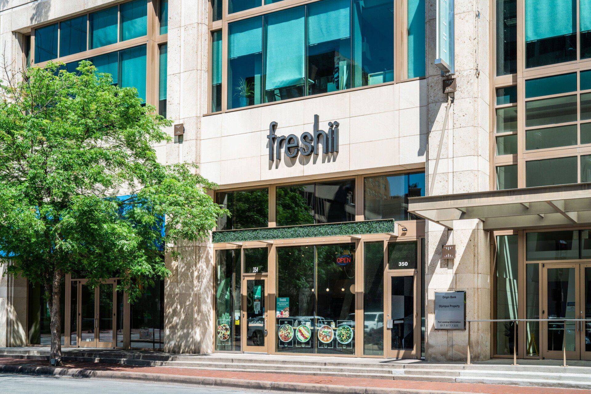 A large building with a sign that says freshii on it.