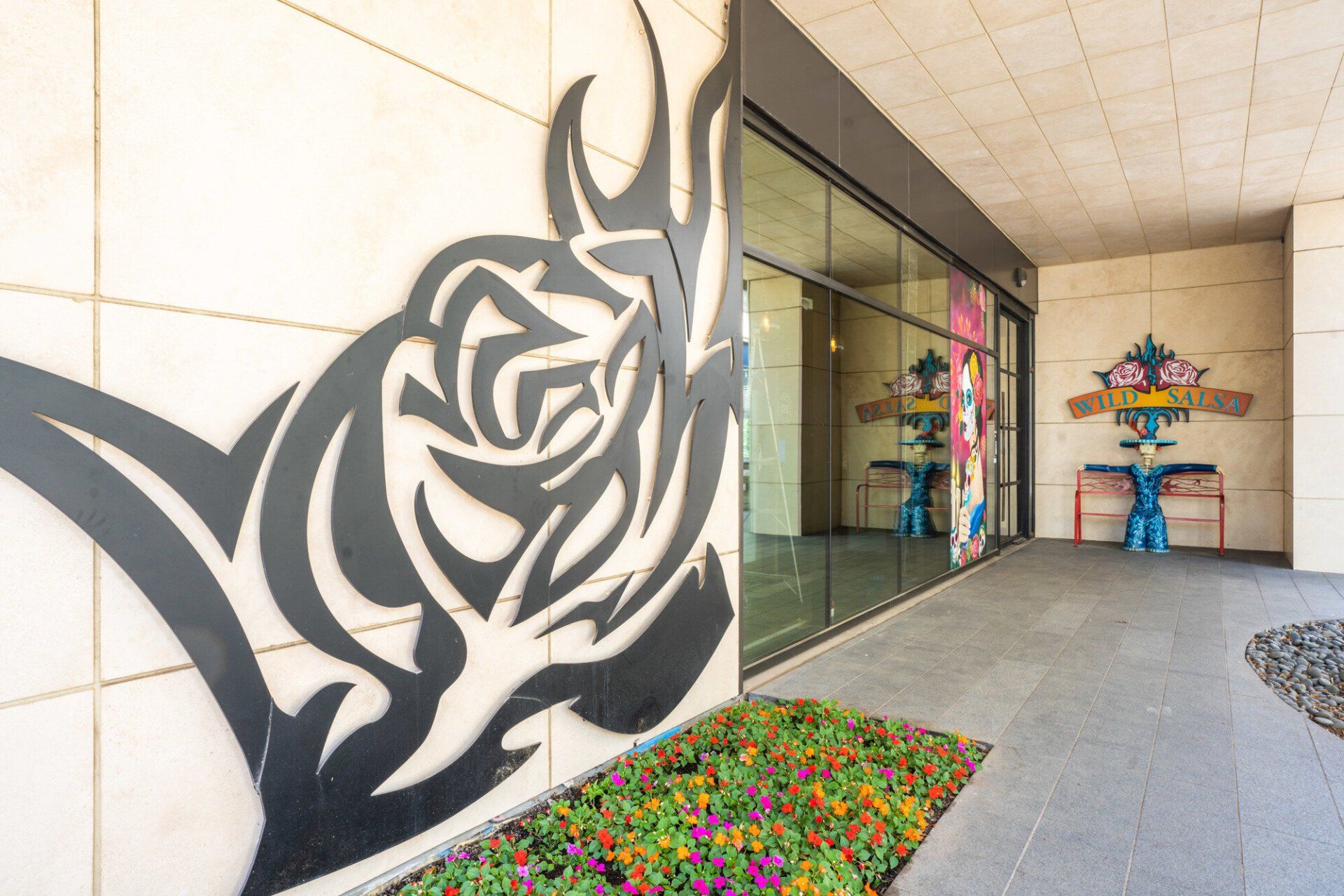 A sculpture of a rose is on the side of a building