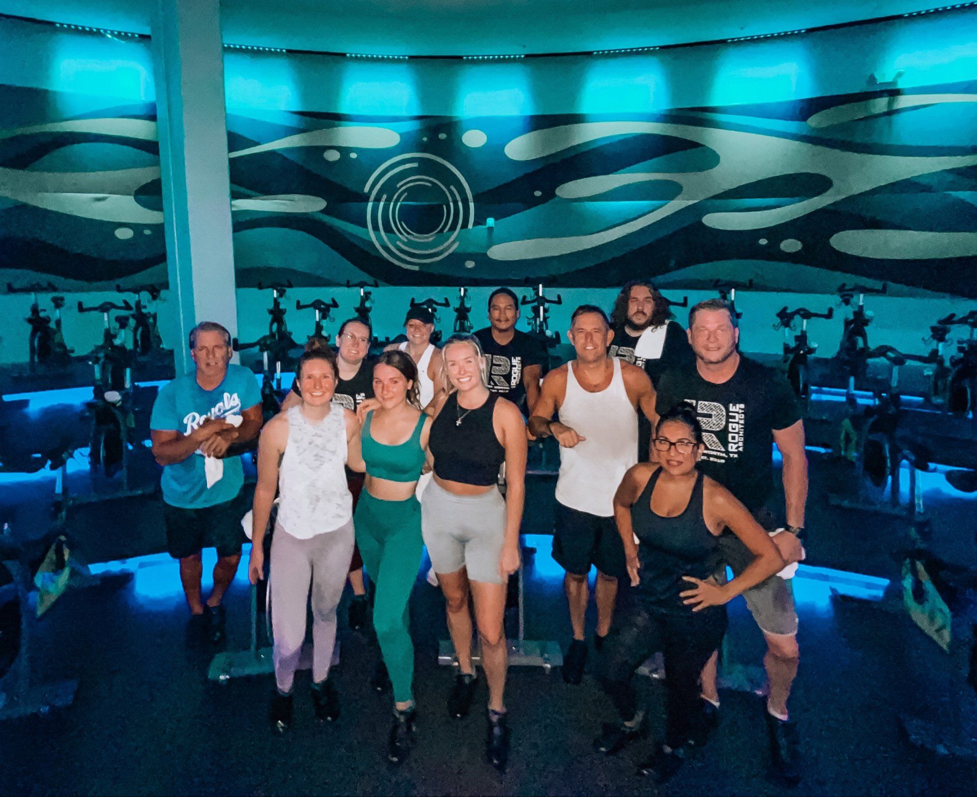 A group of people are posing for a picture in a gym.
