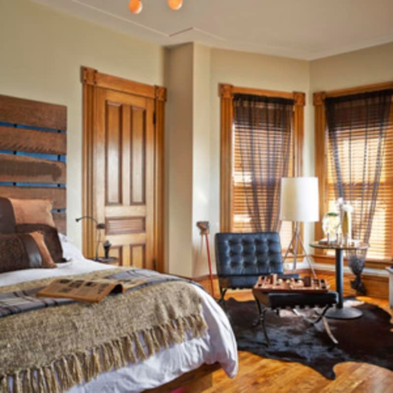 A bedroom with a large bed and a chair