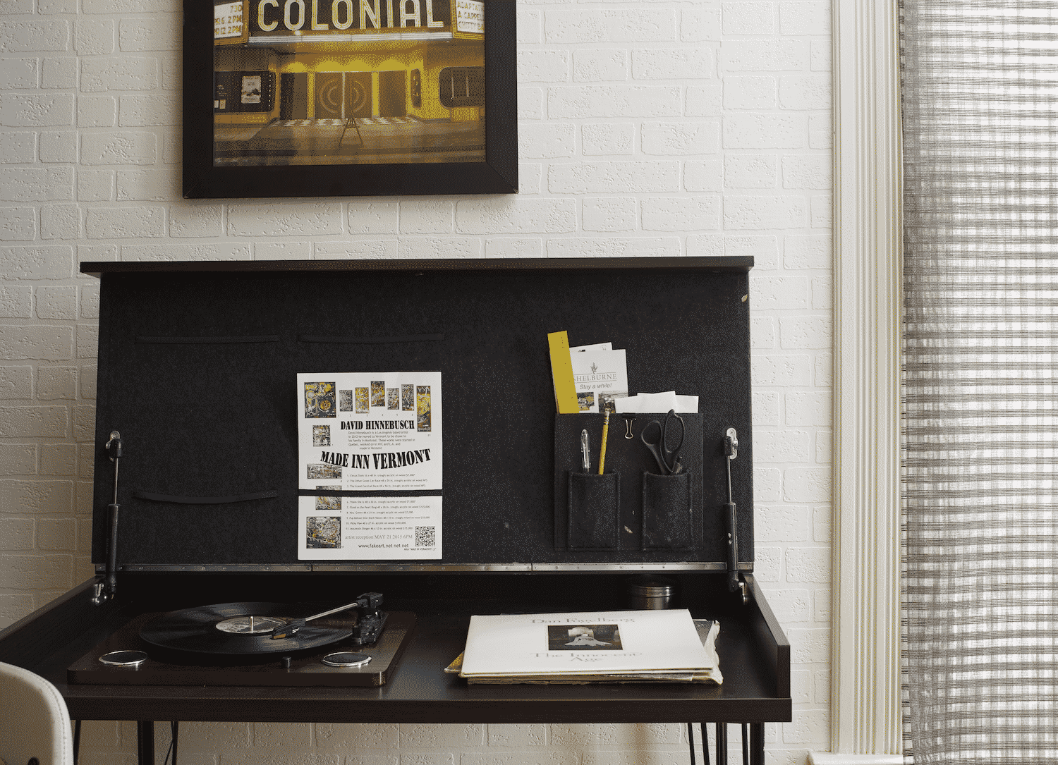 A picture of a colonial store hangs above a desk