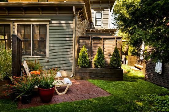 A backyard with a patio and chairs in front of a house.