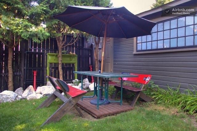 A table and chairs under an umbrella in a backyard