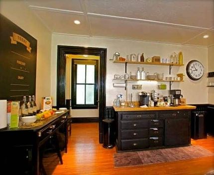 A kitchen with a clock on the wall and a chalkboard that says breakfast
