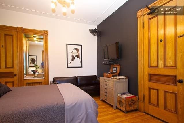 A bedroom with a bed a couch and a television