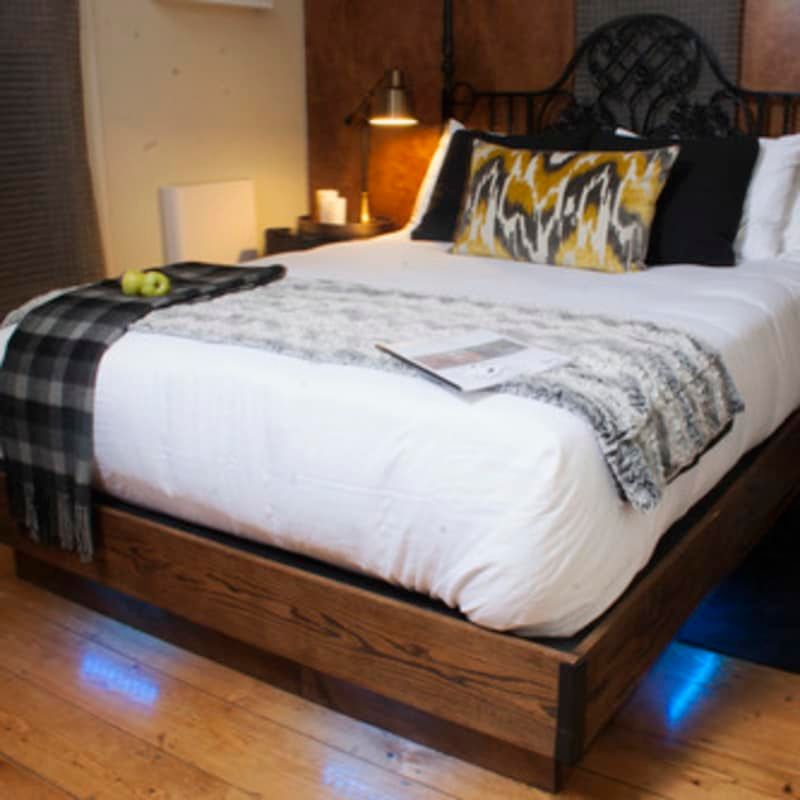 A bed with white sheets and a plaid blanket on it