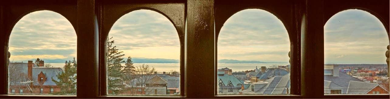 A row of arched windows with a view of a city