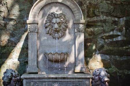 There is a fountain with a lion head on it.