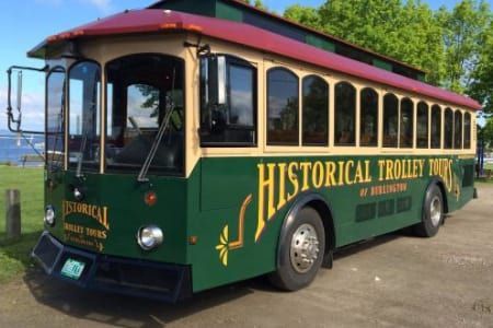 A green and tan trolley that says historical trolley tour