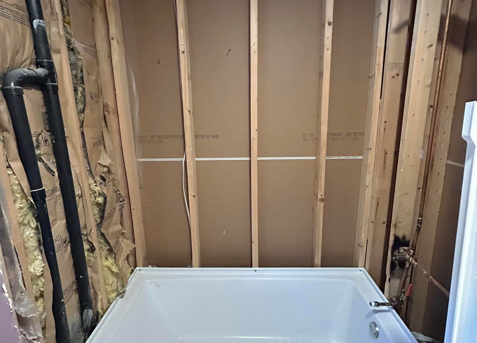 Modern bathroom with navy blue textured walls, white countertops, glass shower, and pebble floor.