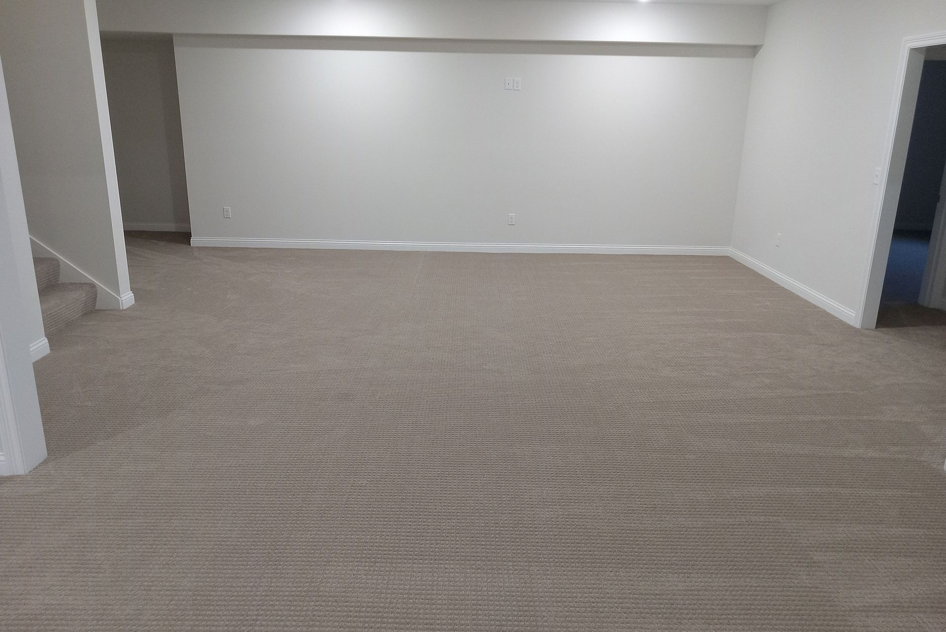 Empty room with beige carpet, white walls, and a doorway.