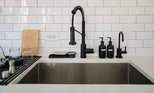 Modern kitchen with white cabinets, countertops, and subway tile backsplash. Includes gas stovetop, oven, and microwave.