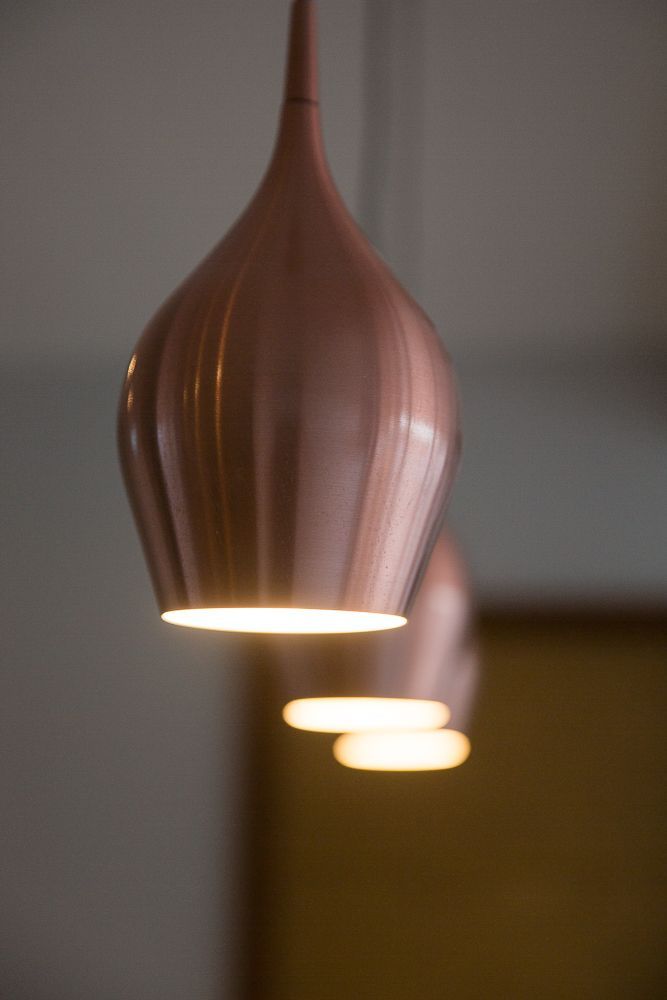 Trio of copper pendant lights hanging in soft focus.