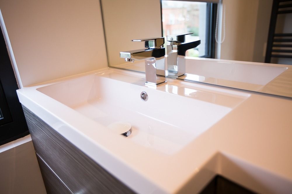 Modern bathroom sink with sleek chrome faucet and wood cabinetry.
