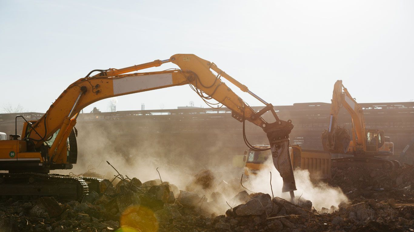 A couple of excavators are working on a construction site.