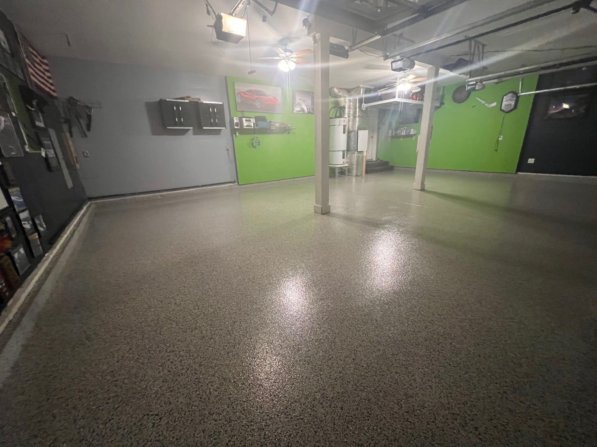 Garage with shiny, speckled concrete floor, gray and lime green walls, and bright overhead lights.