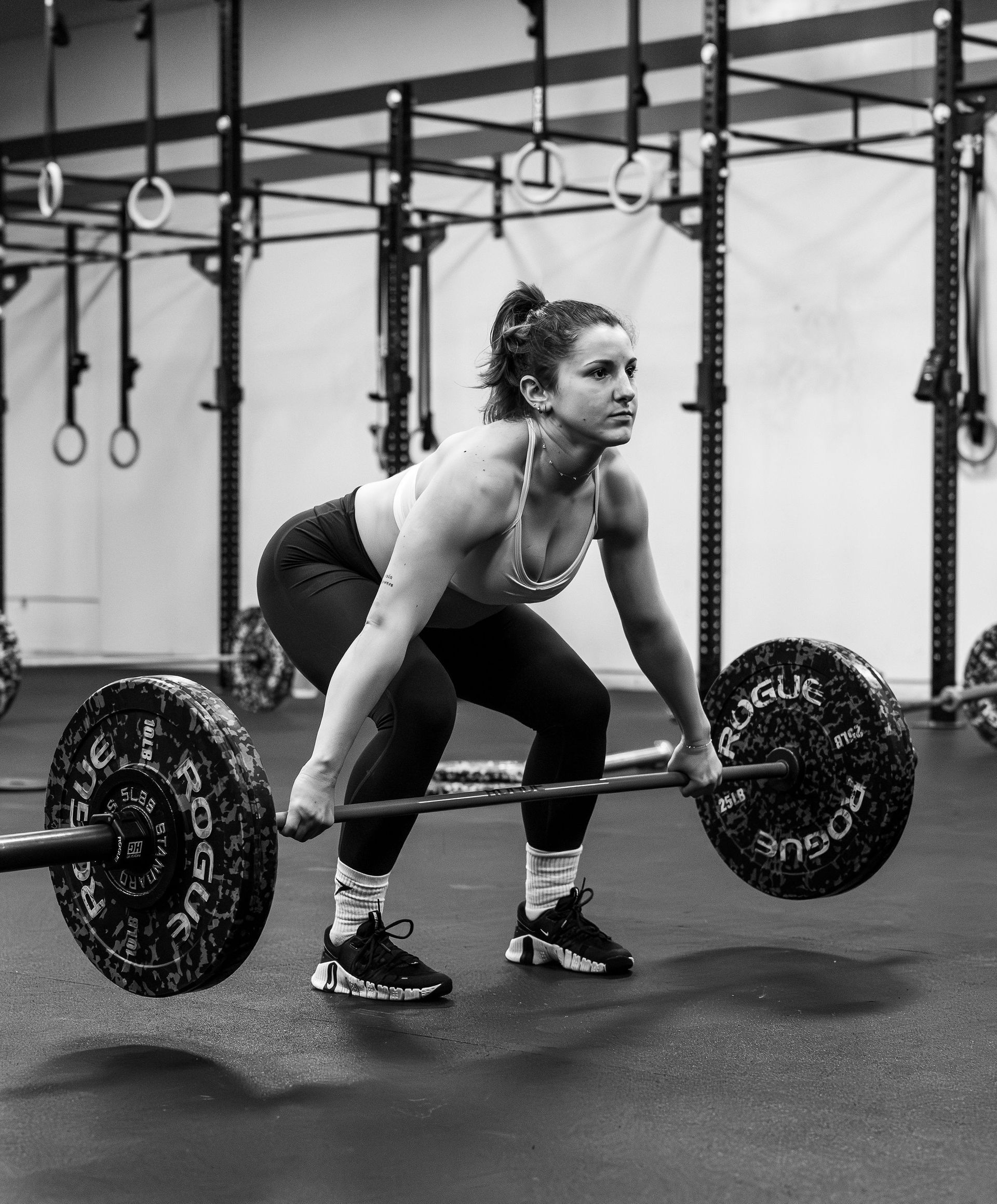 Une femme soulève une barre dans une salle de sport