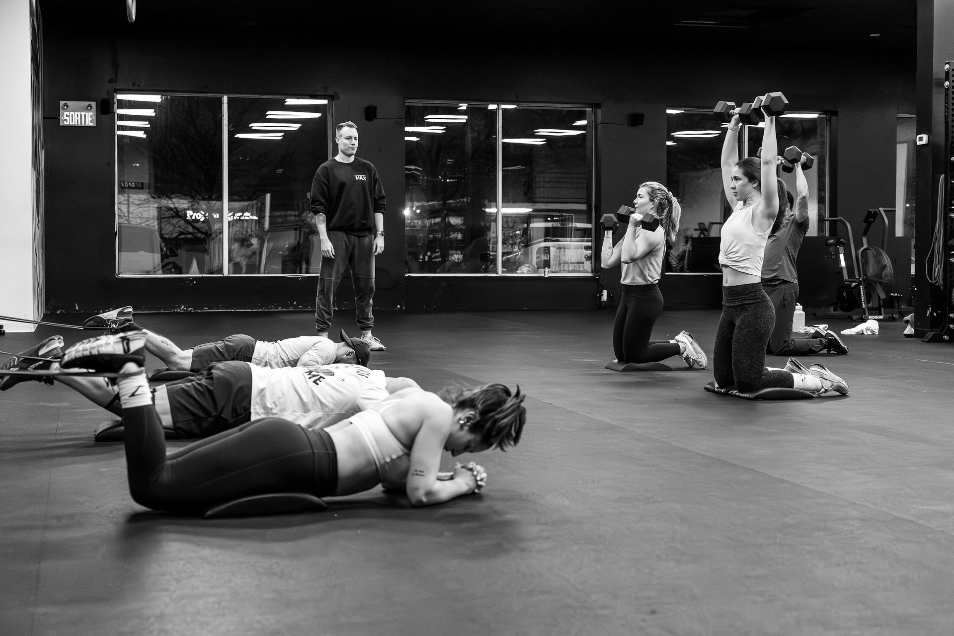 A woman is lifting a barbell in a gym