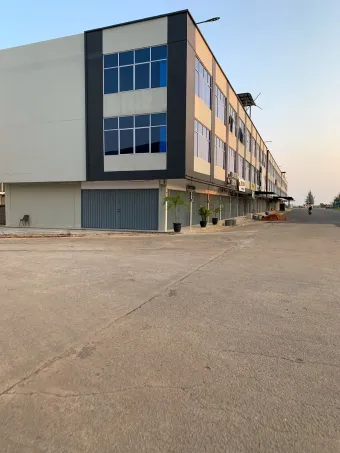 Bank building with beige and brick facade, large windows, and a clear blue sky.