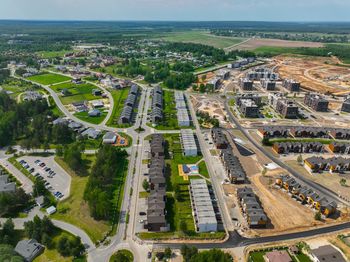 Blue dumpster on a construction site with a partially framed house in the background.