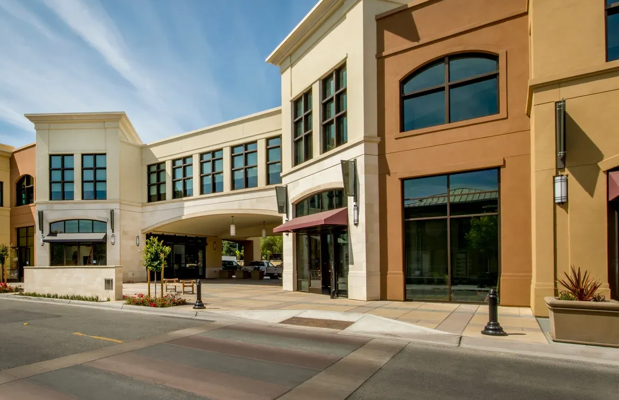 Blue house with white columns, a brick path, and green lawn.