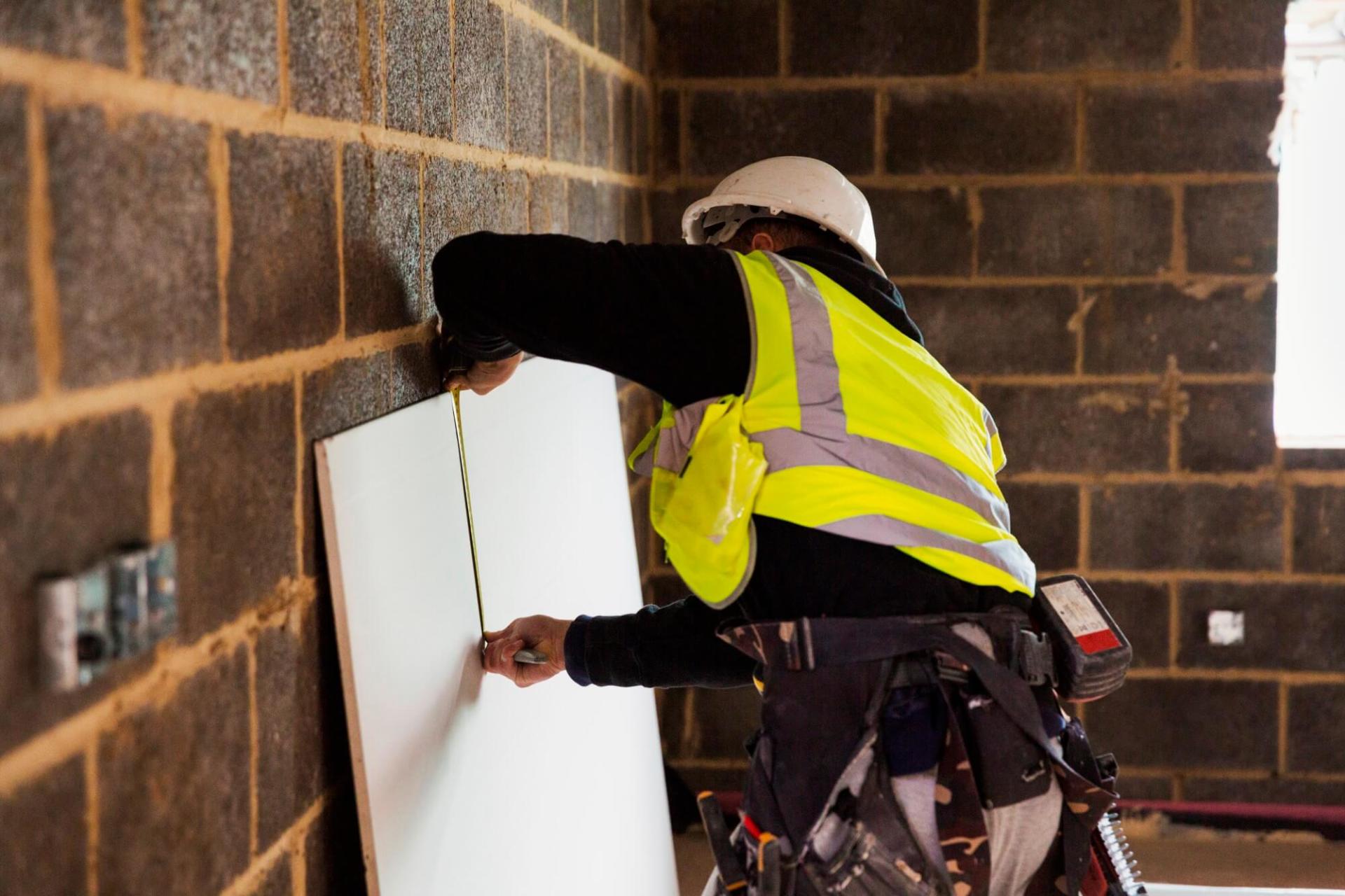 A building professional measuring length