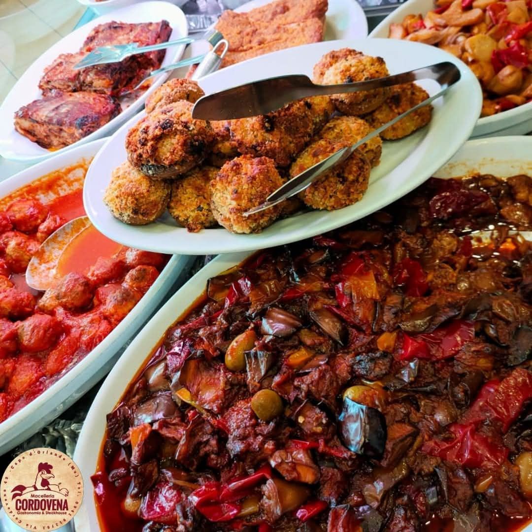 Varietà di piatti: polpette fritte, stufato, piatti a base di pomodoro e carne su piatti bianchi.