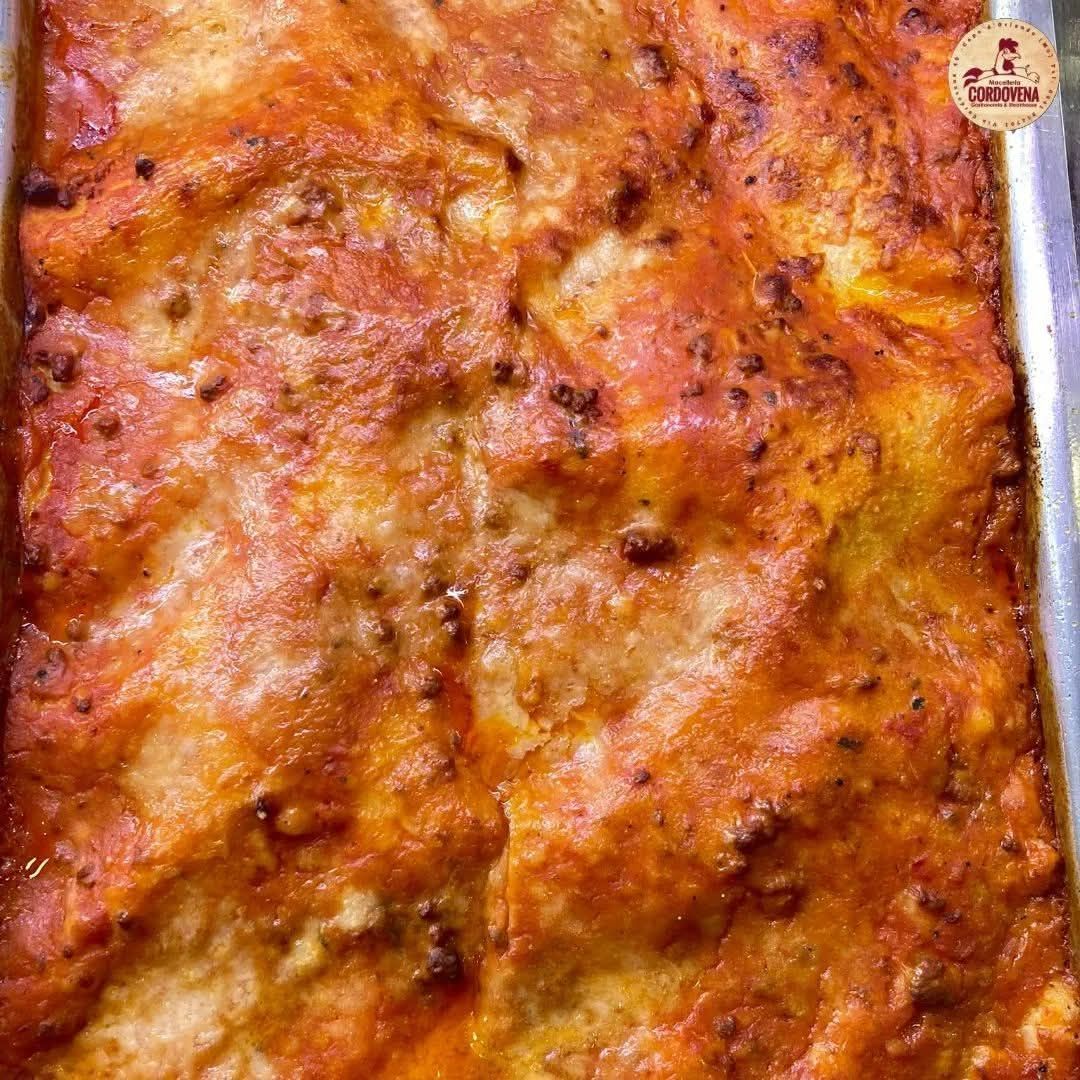 Lasagna cotta al forno in una teglia di metallo; sono visibili gli strati di pasta, salsa e formaggio.