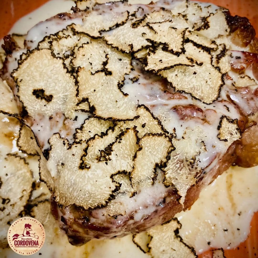 Bistecca condita con fettine di tartufo e salsa cremosa.