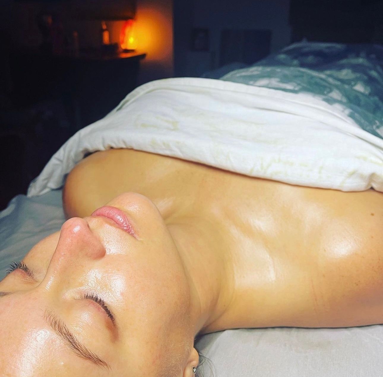 A woman is laying on a table with her eyes closed