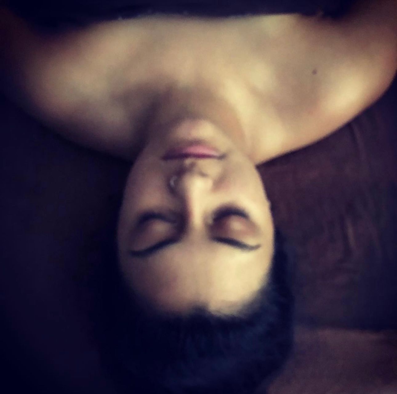 A woman laying upside down with her eyes closed