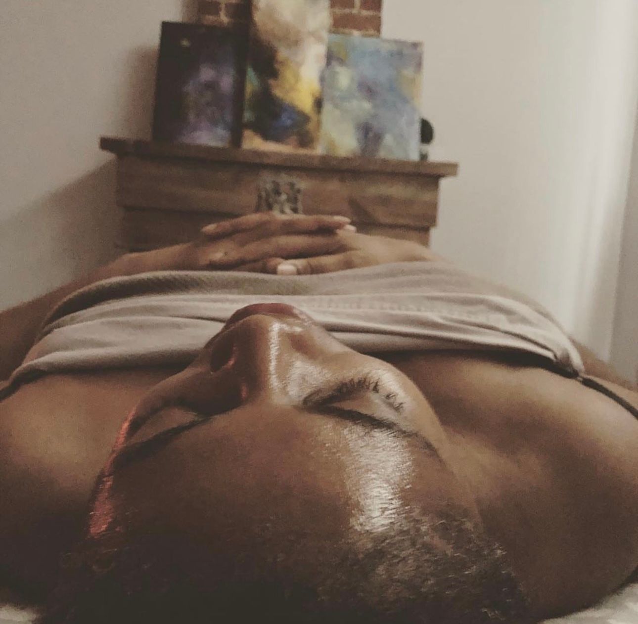 A woman is laying on her stomach with her eyes closed