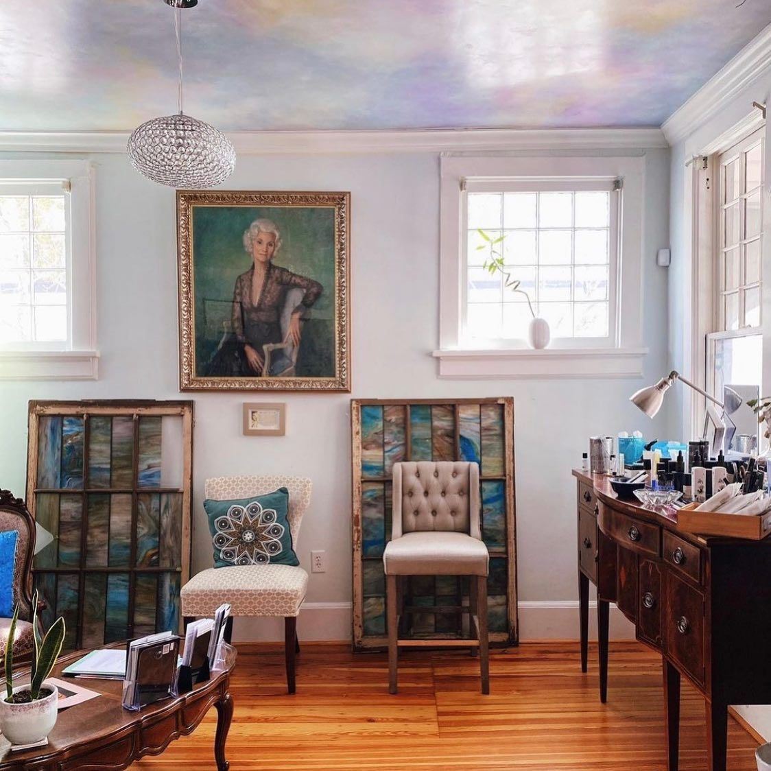 A living room with a painting of a woman on the wall