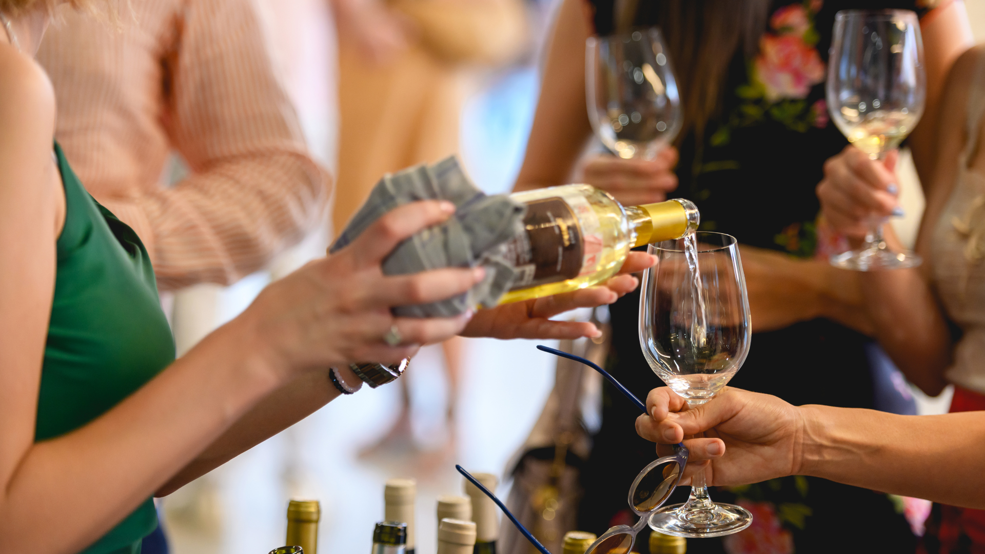 A woman is pouring wine into a glass at a wine tasting.