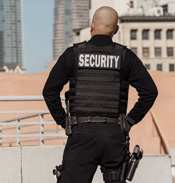 A man wearing a black vest with the word security on it
