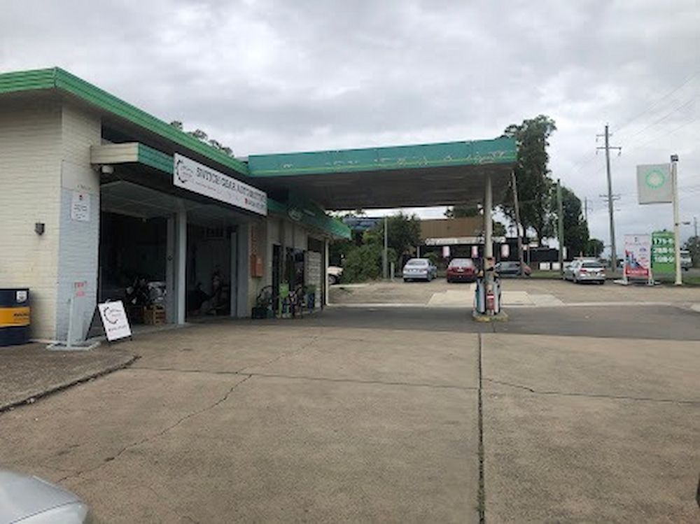 A Gas Station With Cars Parked in Front of It on a Cloudy Day — Switch Gear Automotive in Riverstone, NSW