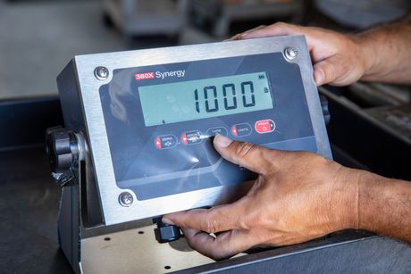 Person adjusts a digital scale that reads 1000.